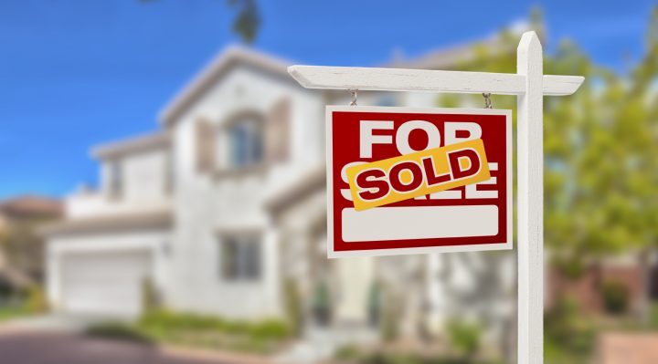 Sold Home For Sale Real Estate Sign in Front of Beautiful New House.